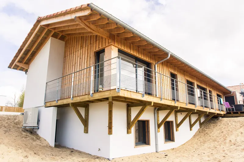 Maison à ossature bois avec bardage bois et terrasse en balcon